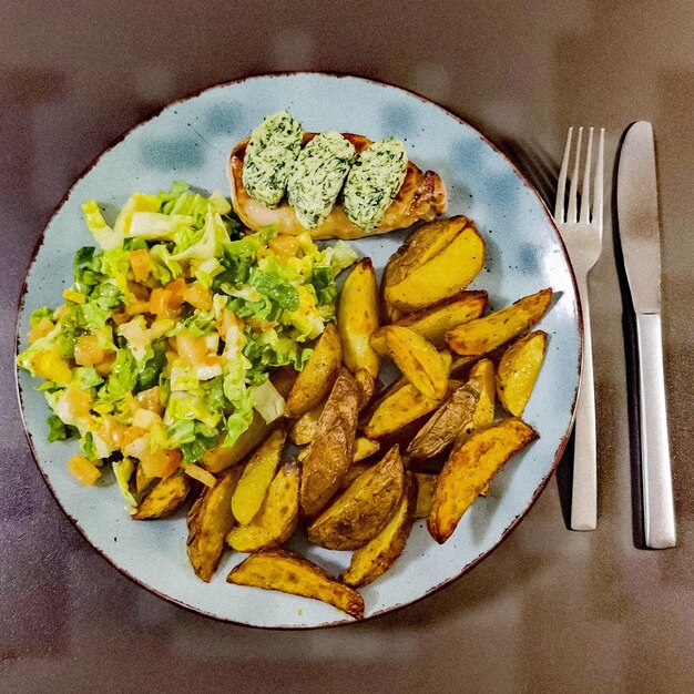 A plate of food with a salad and potatoes.