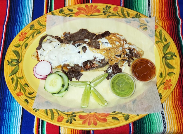 A plate of food with a sauce on it and a plate with a mexican food on it.