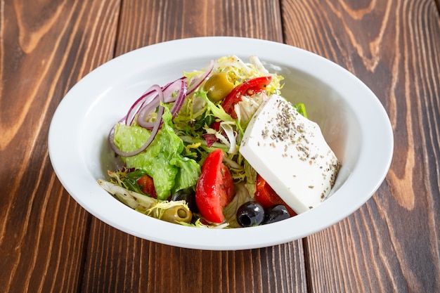 Plate of fresh greek salad on wooden table