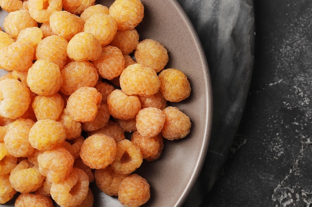 Plate full of ripe yellow raspberries top view Top view Lots of yellow raspberries Dessert berries