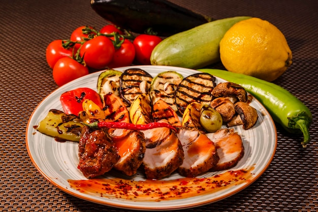 A plate full of tasty grilled meat served with sauce and pepper with lots of ingredients