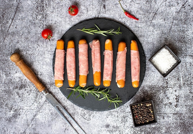 A plate of ham wrapped in ham on a table with a knife and a knife.