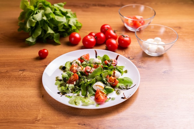 Plate of healthy classic closeup caprese salad with mozzarella cheese tomatoes and basil in kitchen italian cuisine