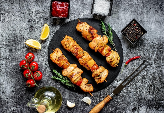 A plate of kebabs with lemon and red wine on the table