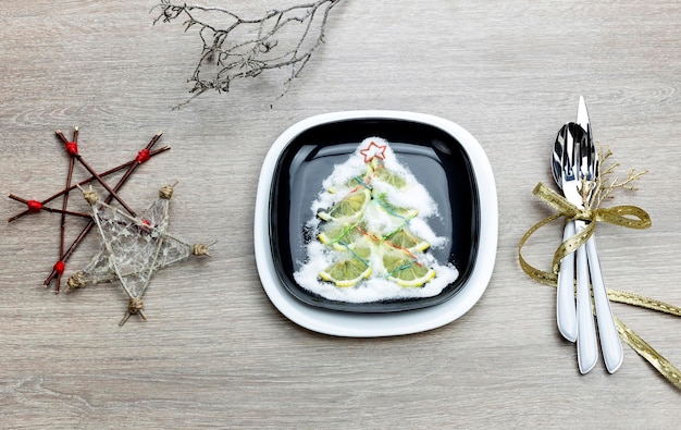 Plate knife fork and a variety of Christmas decorations on a table closeup