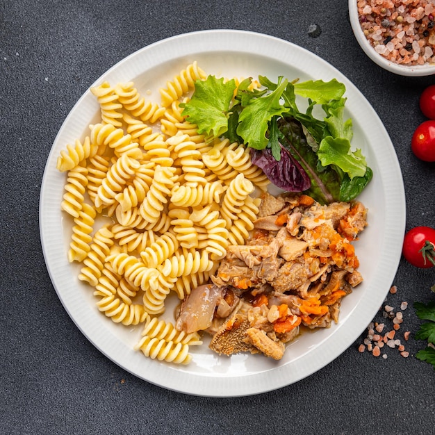 A plate of pasta and salad with a salad on the side.