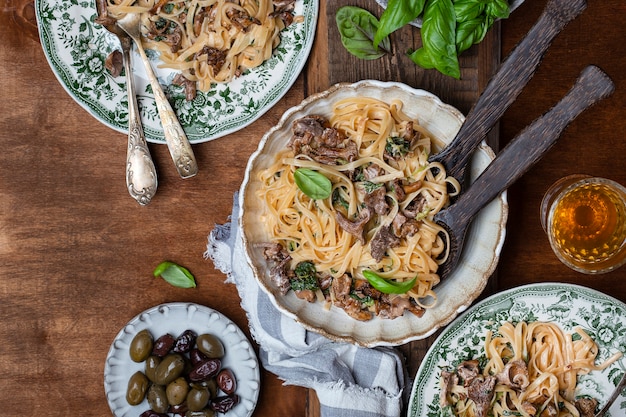 Plate of pasta with forest chanterelles and green basil