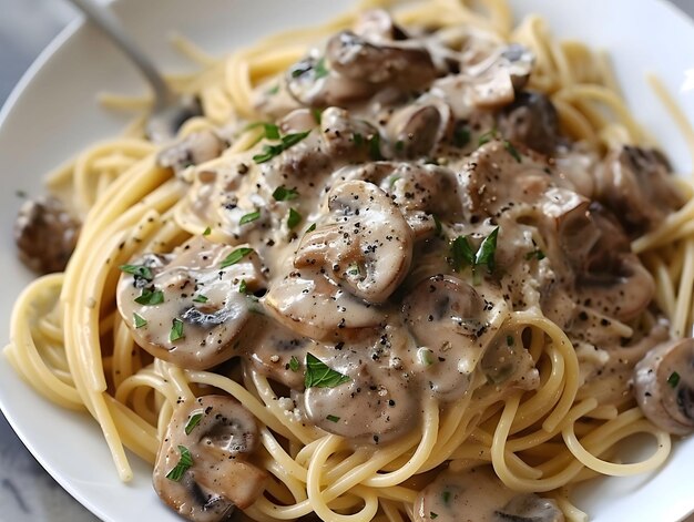 A plate of pasta with mushrooms and parsley on top