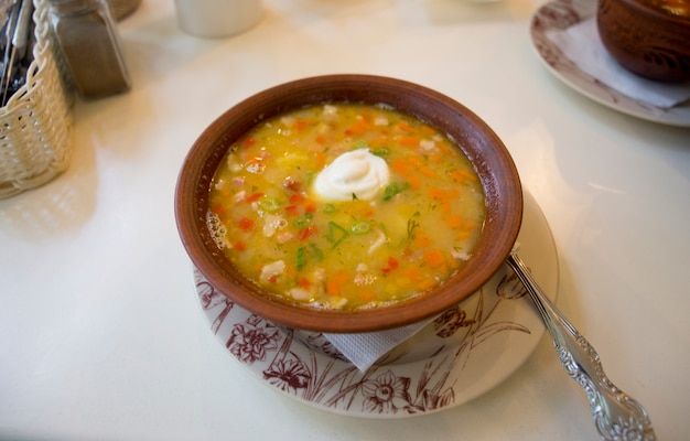 A plate of pea soup with sour cream