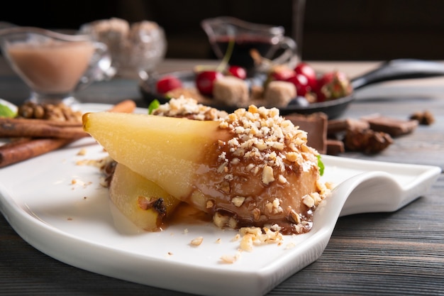 A plate of pear dessert with wine sauce on a dark wooden table