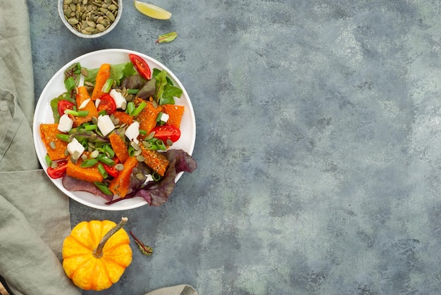 A plate of salad with a pumpkin on the side