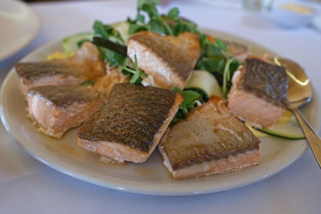 A plate of salmon with a salad on the side