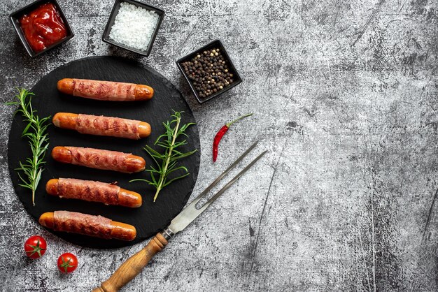 A plate of sausages with a knife and a knife on a gray background.