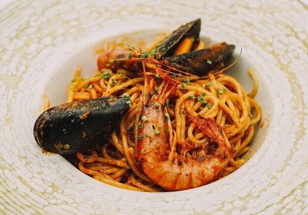 A plate of spaghetti with seafood and tomato sauce