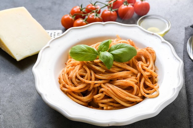 Plate of spaghetti with tomato sauce and basil and cheese top view