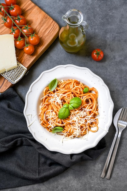 Plate of spaghetti with tomato sauce and basil and cheese top view