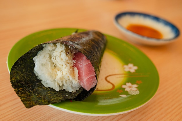 A plate of sushi with a bowl of sauce on it.