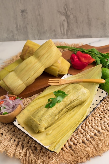 Photo a plate of tamales with a fork and spoon on it.