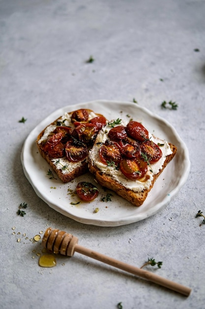 A plate of toast with tomatoes and cream on it