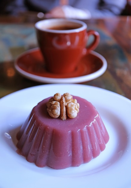 Plate of Traditional Georgian Sweets Called Pelamushi with Blurry Hot Coffee