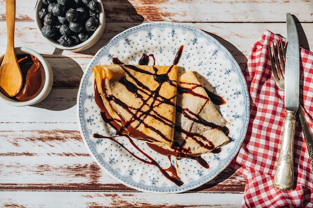 Plate two exquisite homemade pancakes or crepes filled with almond cream and chocolate with chocolate threads covering Aerial view general shot