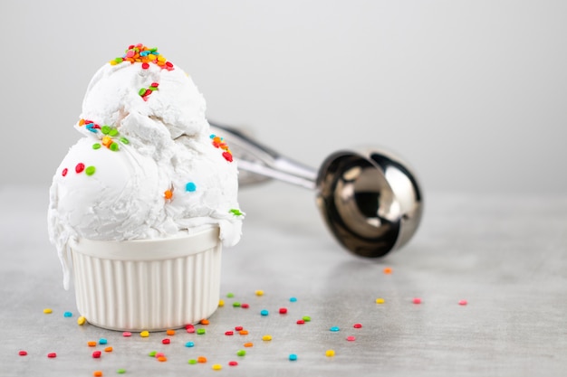 Plate of vanilla ice cream scoop swith sprinkles and waffle cones