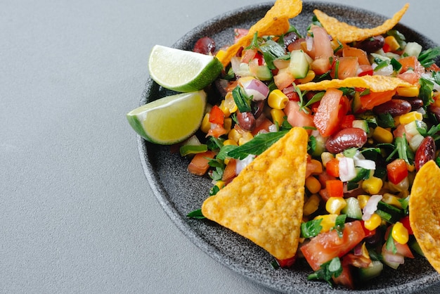 A plate of vegetable salsa is a mexican snack food chips with salsa on a plate top view grey backgro