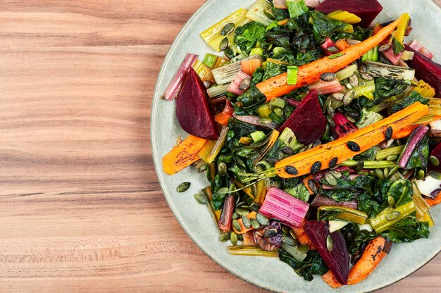 A plate of vegetables with a wooden background