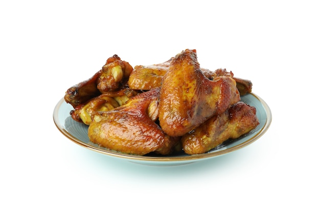 Plate with baked chicken wings isolated on white background