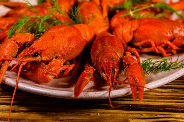 Plate with boiled crayfishes on rustic wooden table