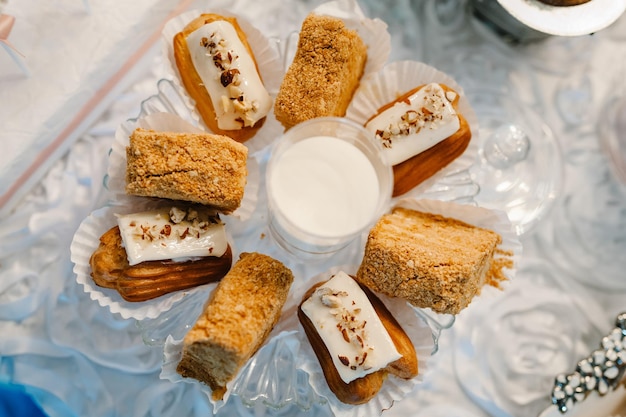 Plate with cakes decorated dessert table for a party Delicious sweets on buffet Table with muffins candy for a party goodies on wedding banquet area Close up candy bar flat lay top view