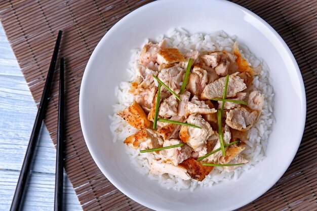 Plate with chicken and rice on wicker mat