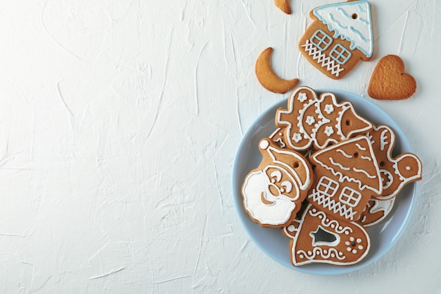 Plate with Christmas cookies on white, top view. Space for text