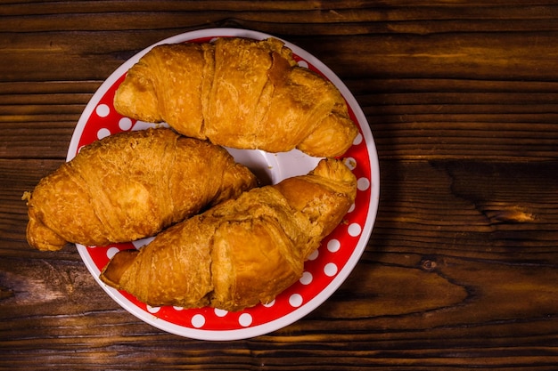 Plate with croissants on a wooden table Top view