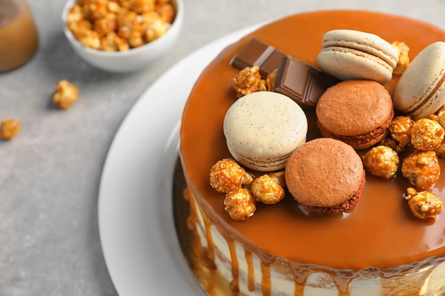 Plate with delicious caramel cake on table