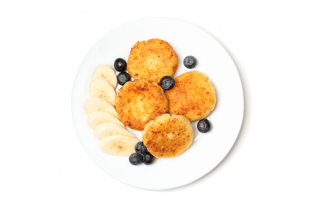 Plate with delicious cheese pancakes isolated on white surface