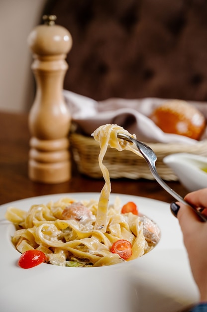 Plate with delicious Chicken Alfredo on table