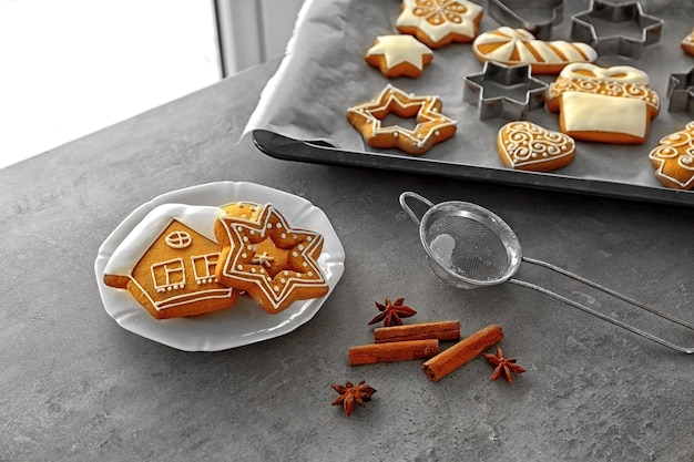 Plate with delicious Christmas cookies and spices on table