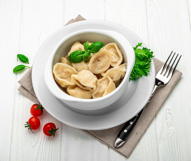 Plate with delicious handmade dumplings on white background