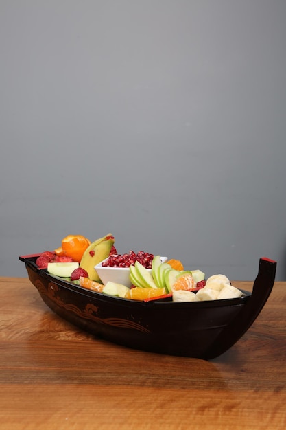 Plate with delicious mixed fruits and sliced fruits