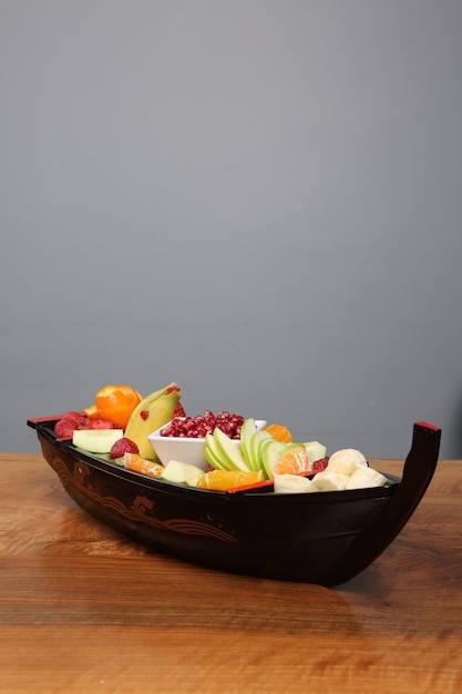 Plate with delicious mixed fruits and sliced fruits