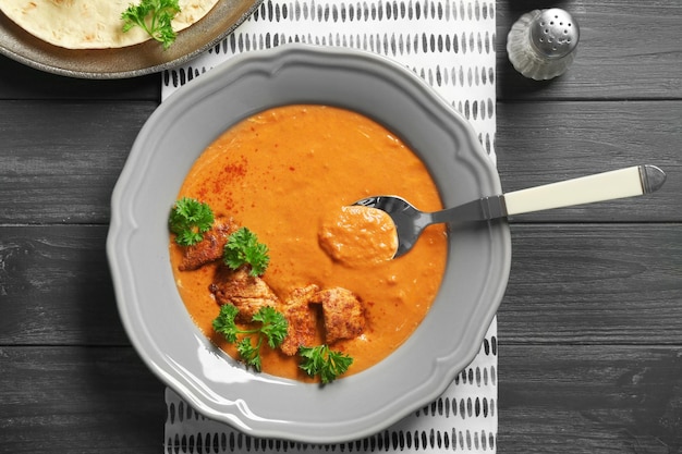 Plate with delicious Murgh Makhani on table