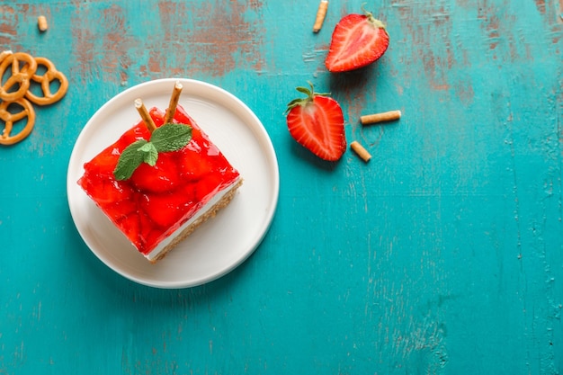 Plate with delicious strawberry pretzel salad on table