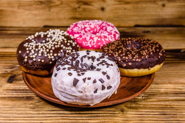 Plate with glazed donuts on a wooden table