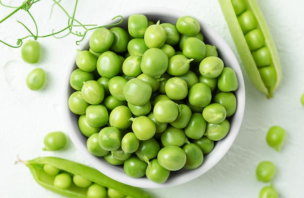 Plate with green peeled peas top view