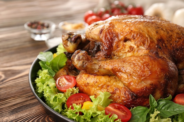 Plate with roasted turkey and vegetables on table