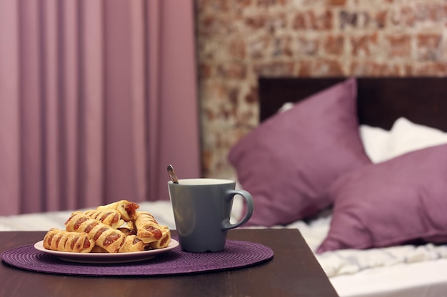 Plate with a sweet dessert and a mug on the table on a blurry background