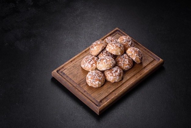 Plate with tasty homemade gingerbread cookies on dark concrete table