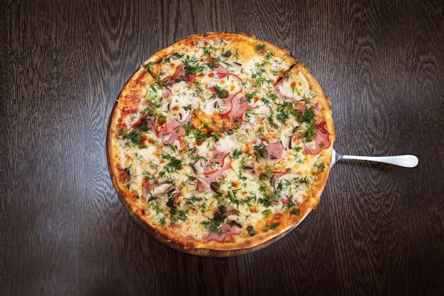 Plate with tasty pizza on wooden table