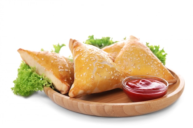 Plate with tasty samsa and sauce